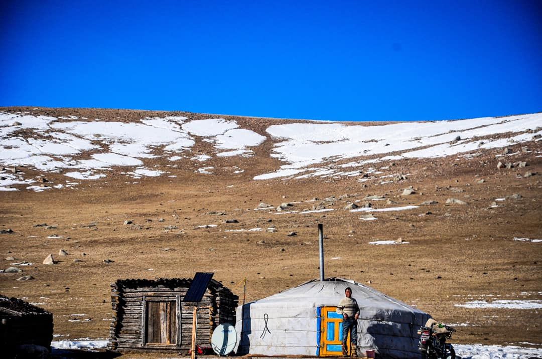 Man standing in front of his yurt.