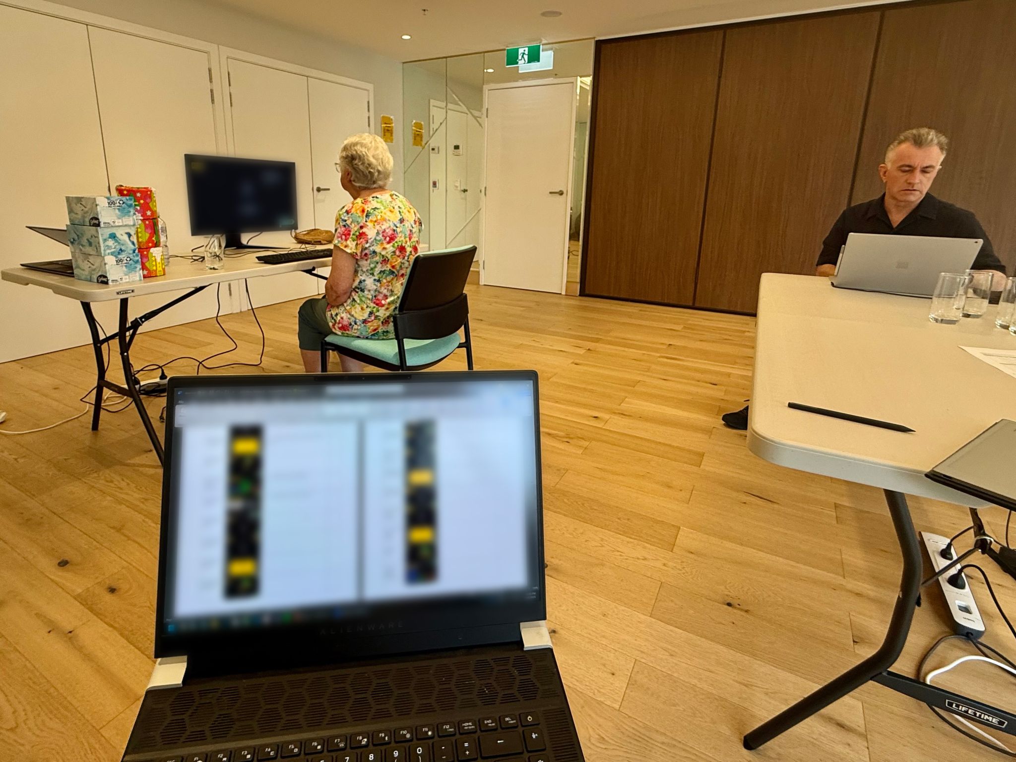 An open laptop, facing Jonathan Duckworth and an elderly person in a user testing session.