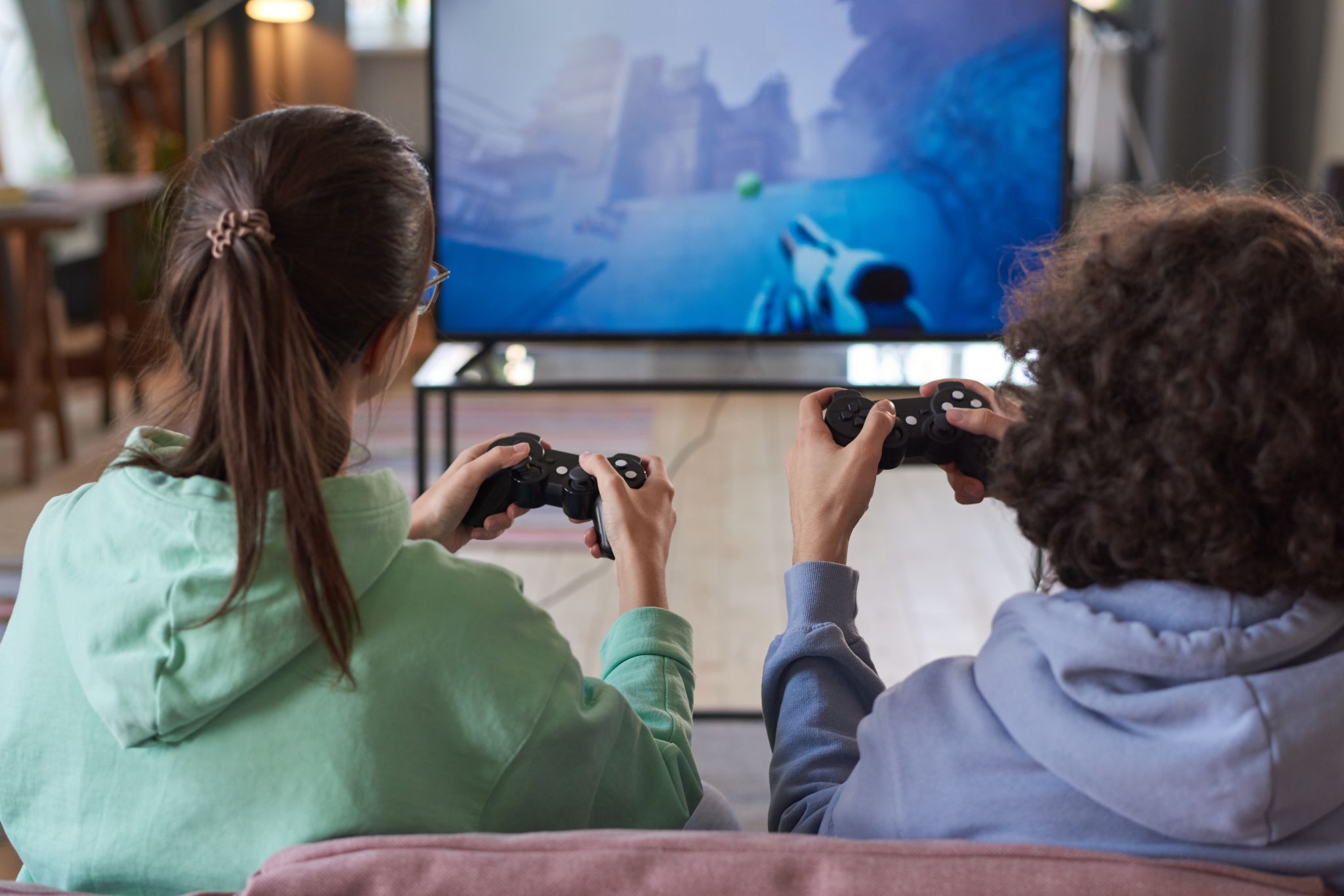 Back of two kids, playing a video game